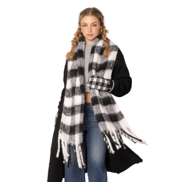 Woman wearing a black and white checkered scarf with tassels on a white background