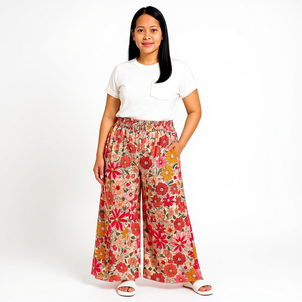 Woman wearing a white t-shirt and colorful floral pants on a white background